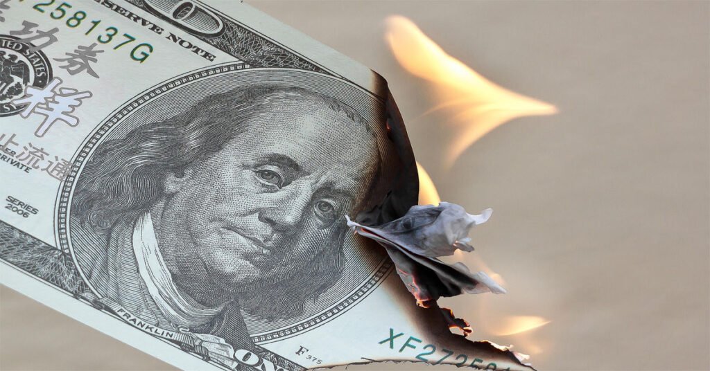 A burning currency note representing the compulsive spending meaning, where money is spent impulsively and its value slowly disappears without conscious control.